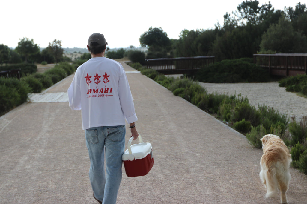 Long sleeve blanca de Jamahi con estampado floral rojo en la espalda, foto en exterior